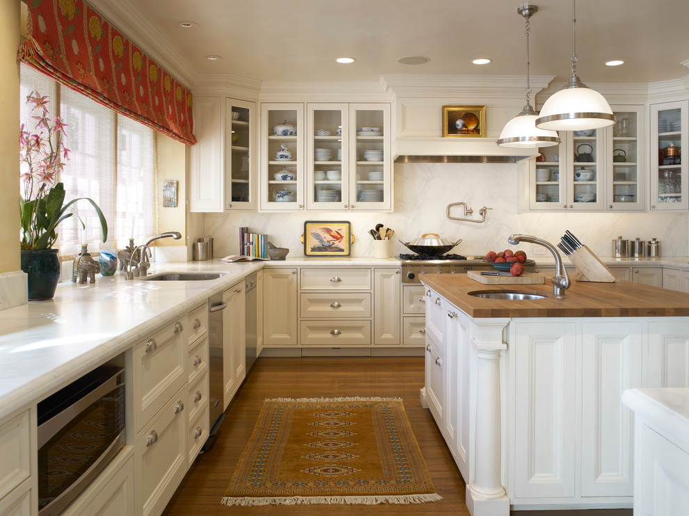 Inspiration för ett vintage kök, med en undermonterad diskho, luckor med infälld panel, vita skåp, träbänkskiva, vitt stänkskydd och rostfria vitvaror