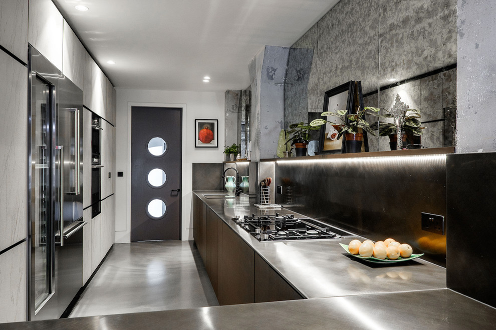 Inspiration for a medium sized industrial l-shaped kitchen in Other with a submerged sink, flat-panel cabinets, stainless steel cabinets, concrete flooring, no island and grey floors.