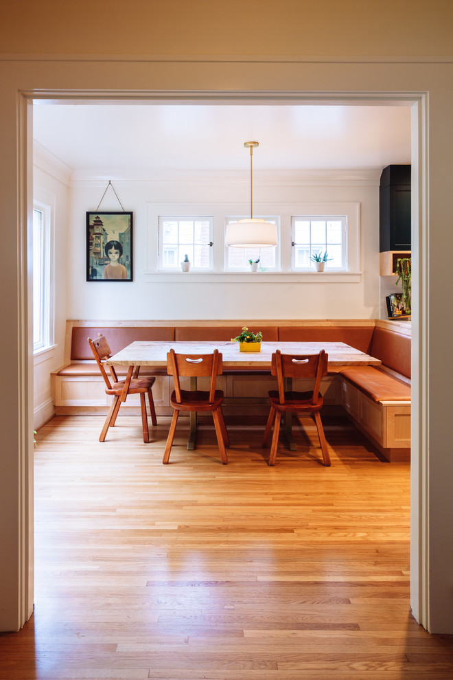 Ispirazione per una sala da pranzo aperta verso la cucina chic di medie dimensioni con parquet chiaro e pavimento marrone