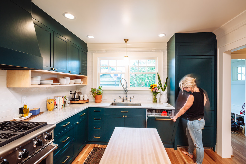 Mid-sized transitional u-shaped light wood floor and brown floor eat-in kitchen photo in Portland with a single-bowl sink, shaker cabinets, green cabinets, marble countertops, white backsplash, ceramic backsplash, paneled appliances and an island