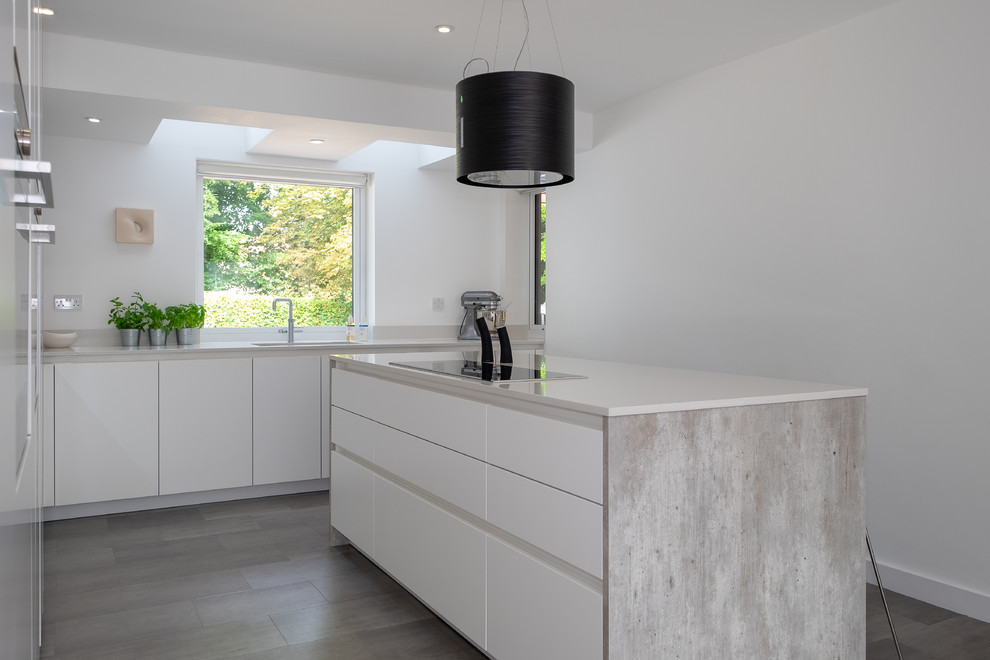Design ideas for a medium sized urban l-shaped open plan kitchen in Hampshire with a submerged sink, flat-panel cabinets, white cabinets, quartz worktops, white splashback, stainless steel appliances, lino flooring, an island, multi-coloured floors and white worktops.