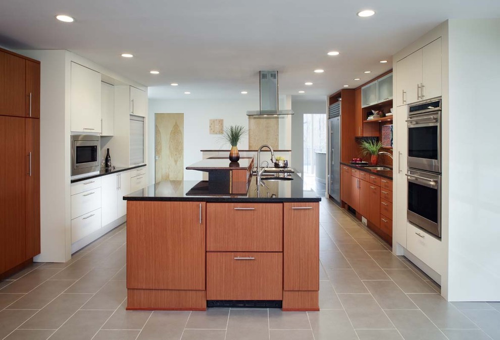 Zweizeilige Moderne Küche mit Küchengeräten aus Edelstahl, Unterbauwaschbecken, flächenbündigen Schrankfronten und hellbraunen Holzschränken in San Diego
