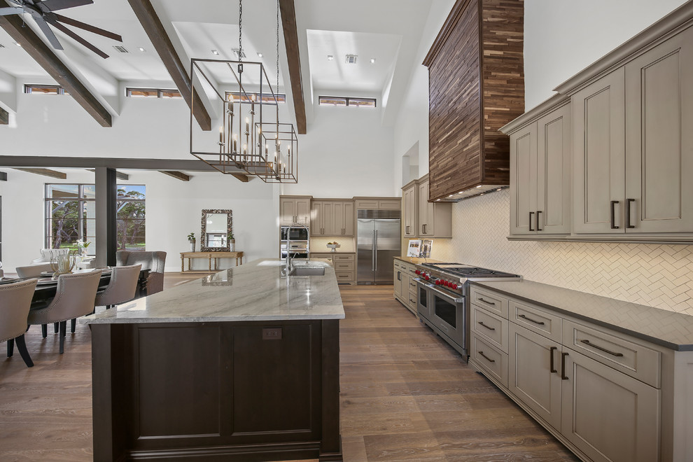 Inspiration for a large transitional u-shaped porcelain tile and brown floor open concept kitchen remodel in Austin with a drop-in sink, flat-panel cabinets, medium tone wood cabinets, marble countertops, white backsplash, porcelain backsplash, stainless steel appliances and an island