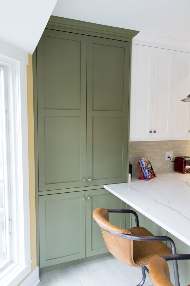 Foto på ett mellanstort funkis vit kök, med en rustik diskho, luckor med infälld panel, gröna skåp, bänkskiva i kvartsit, grönt stänkskydd, stänkskydd i tunnelbanekakel, rostfria vitvaror, klinkergolv i porslin, en halv köksö och beiget golv