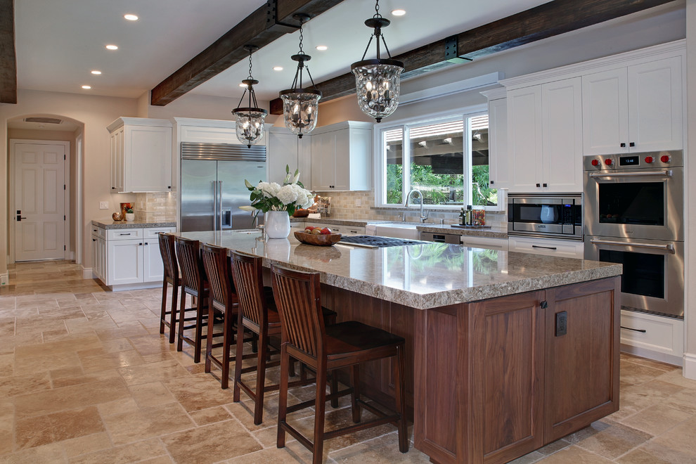 Huge tuscan l-shaped travertine floor and beige floor eat-in kitchen photo in Orange County with a farmhouse sink, shaker cabinets, white cabinets, quartz countertops, multicolored backsplash, ceramic backsplash, stainless steel appliances and an island