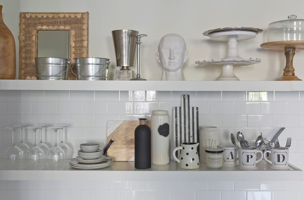 Inredning av ett nordiskt litet kök, med en undermonterad diskho, släta luckor, vita skåp, marmorbänkskiva, vitt stänkskydd, stänkskydd i keramik, rostfria vitvaror och betonggolv