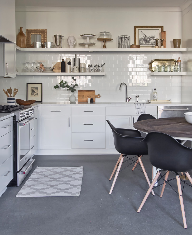 Inspiration for a small scandinavian l-shaped concrete floor eat-in kitchen remodel in Atlanta with an undermount sink, flat-panel cabinets, white cabinets, marble countertops, white backsplash, ceramic backsplash, stainless steel appliances and no island