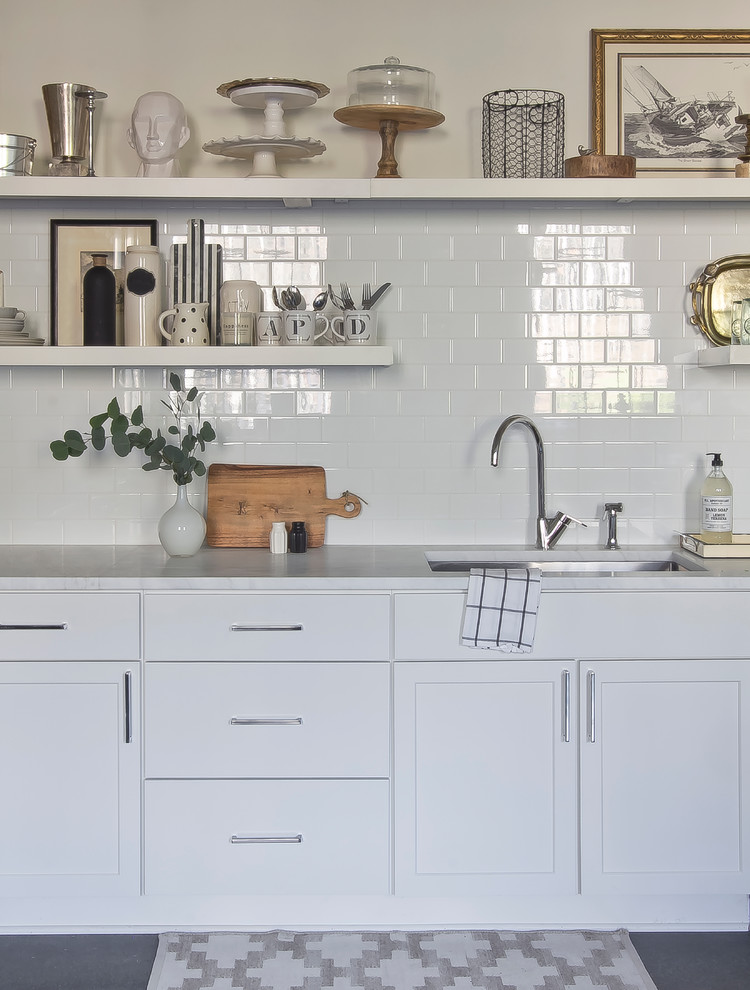Exempel på ett litet skandinaviskt kök, med en undermonterad diskho, släta luckor, vita skåp, marmorbänkskiva, vitt stänkskydd, stänkskydd i keramik, rostfria vitvaror och betonggolv