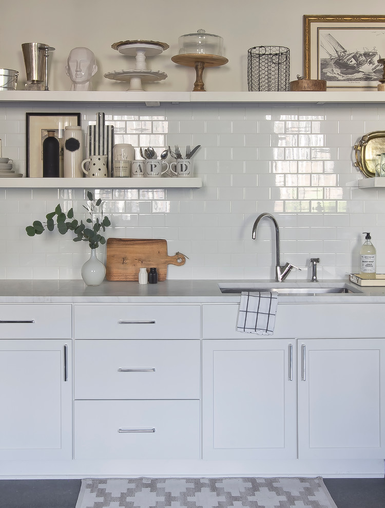 Inspiration for a small scandinavian l-shaped concrete floor eat-in kitchen remodel in Atlanta with an undermount sink, flat-panel cabinets, white cabinets, marble countertops, white backsplash, ceramic backsplash, stainless steel appliances and no island
