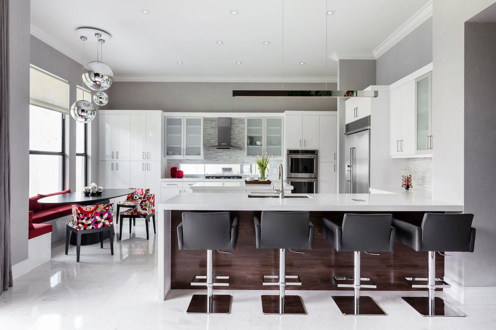 Foto på ett funkis kök, med en dubbel diskho, släta luckor, vita skåp, grått stänkskydd, rostfria vitvaror, en halv köksö och vitt golv