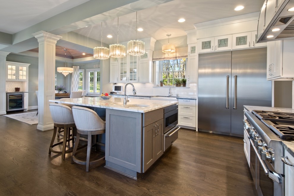 Mid-sized elegant l-shaped dark wood floor eat-in kitchen photo in Cincinnati with a farmhouse sink, shaker cabinets, gray cabinets, soapstone countertops, white backsplash, subway tile backsplash, stainless steel appliances and an island