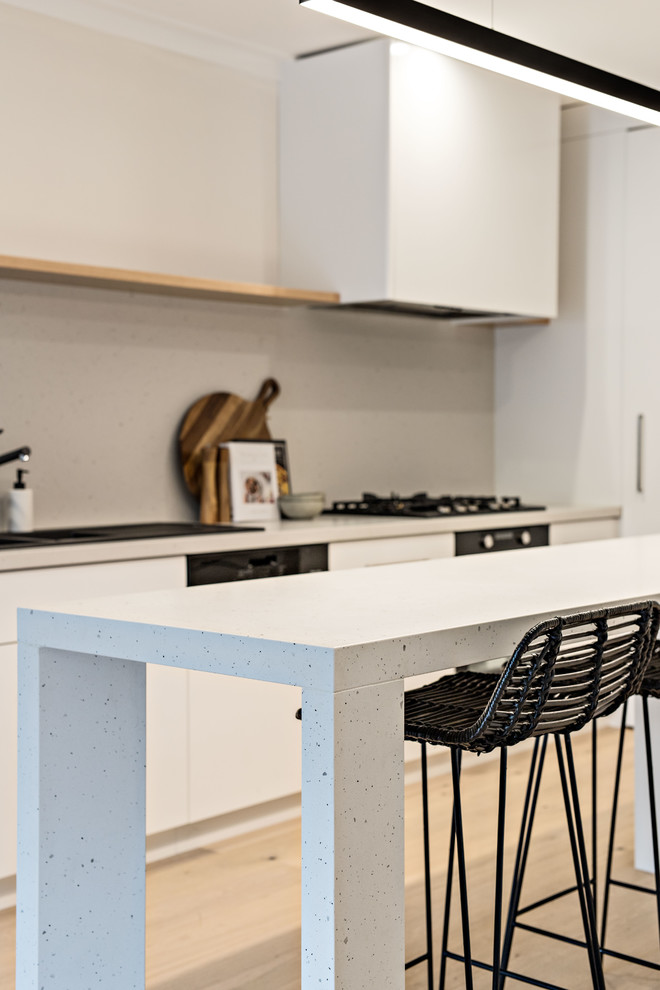 Immagine di una cucina minimal di medie dimensioni con lavello da incasso, ante bianche, top in quarzo composito, paraspruzzi bianco, elettrodomestici da incasso e top bianco