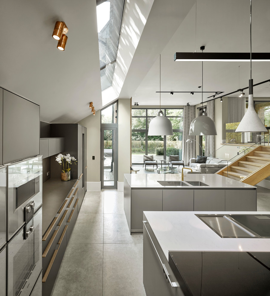 Inspiration för mycket stora moderna grått kök med öppen planlösning, med grå skåp, flera köksöar, en dubbel diskho, släta luckor och grått golv