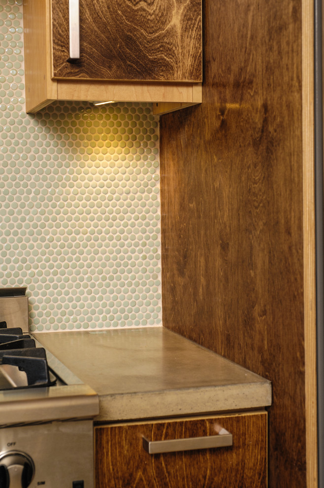 На фото: угловая кухня в стиле модернизм с врезной мойкой, коричневыми фасадами, столешницей из бетона, фартуком из плитки мозаики и техникой из нержавеющей стали с