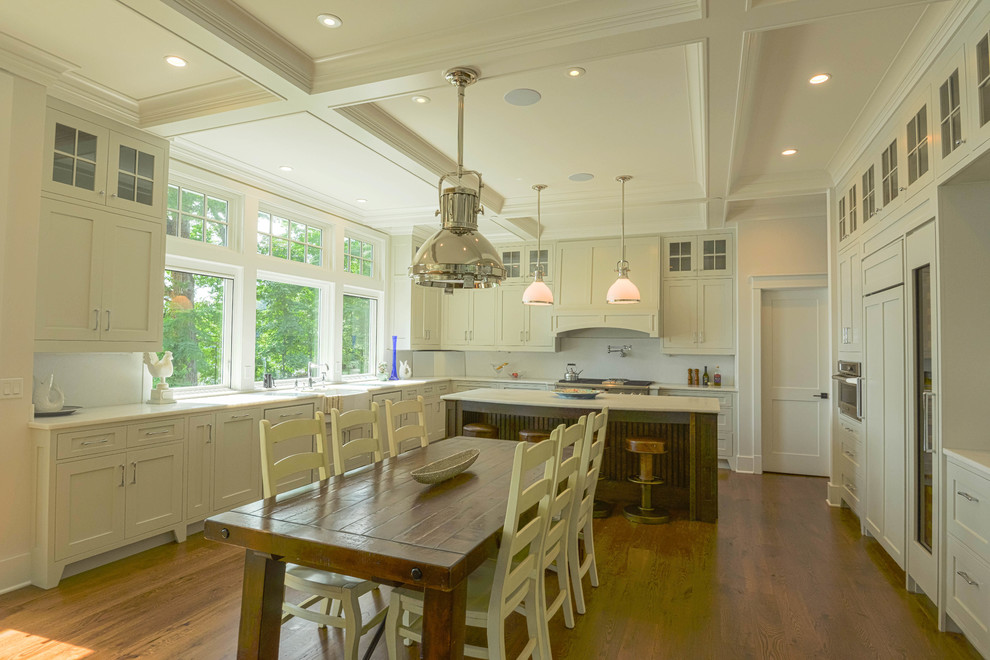 This is an example of a large traditional u-shaped open plan kitchen in DC Metro with beaded cabinets, white cabinets, quartz worktops, white splashback, stone slab splashback, medium hardwood flooring, an island and brown floors.