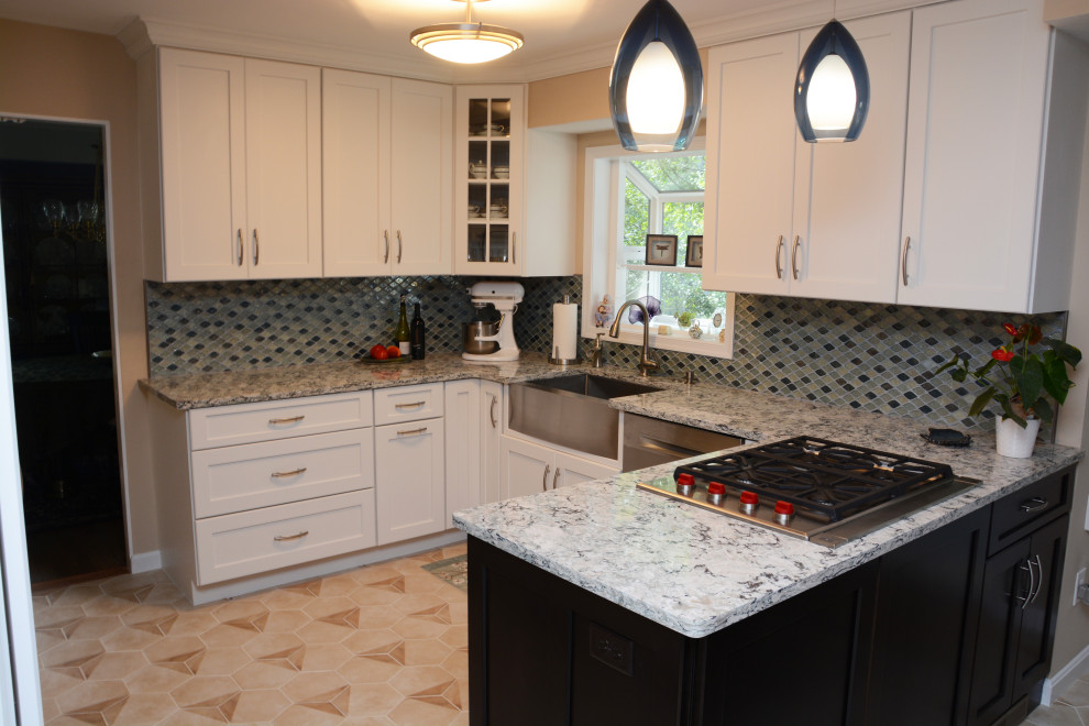 Photo of a medium sized traditional u-shaped enclosed kitchen in Baltimore with a belfast sink, recessed-panel cabinets, white cabinets, engineered stone countertops, blue splashback, stainless steel appliances, a breakfast bar, beige floors and multicoloured worktops.