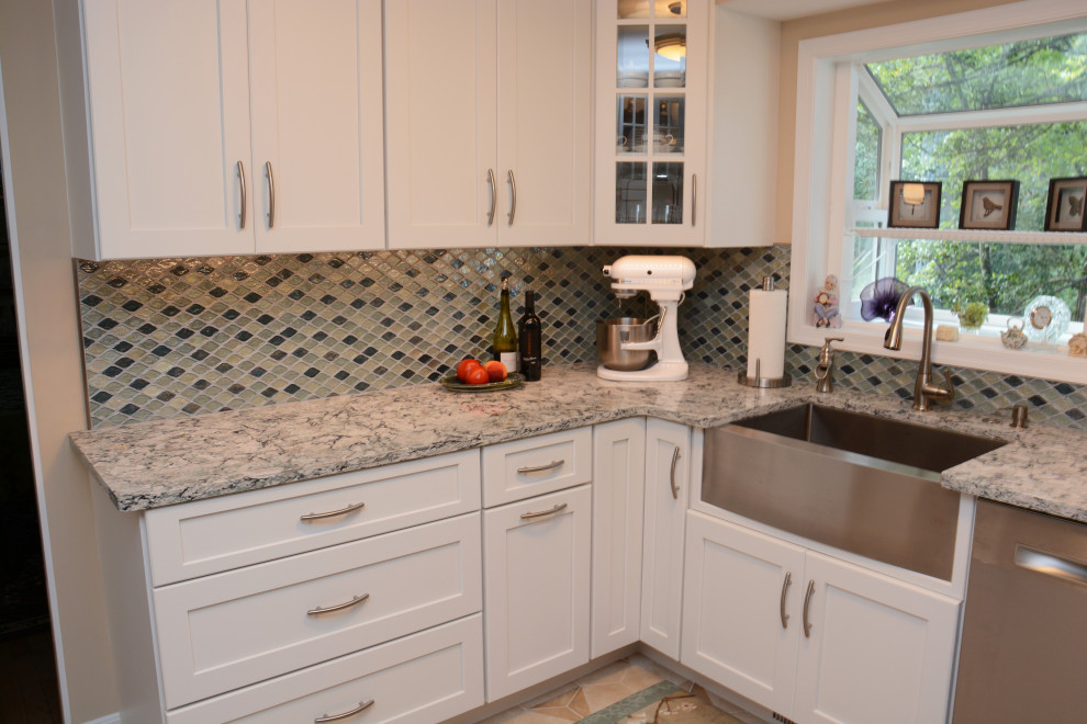 Inredning av ett klassiskt avskilt, mellanstort flerfärgad flerfärgat u-kök, med en rustik diskho, luckor med infälld panel, vita skåp, bänkskiva i kvarts, blått stänkskydd, rostfria vitvaror, en halv köksö och beiget golv