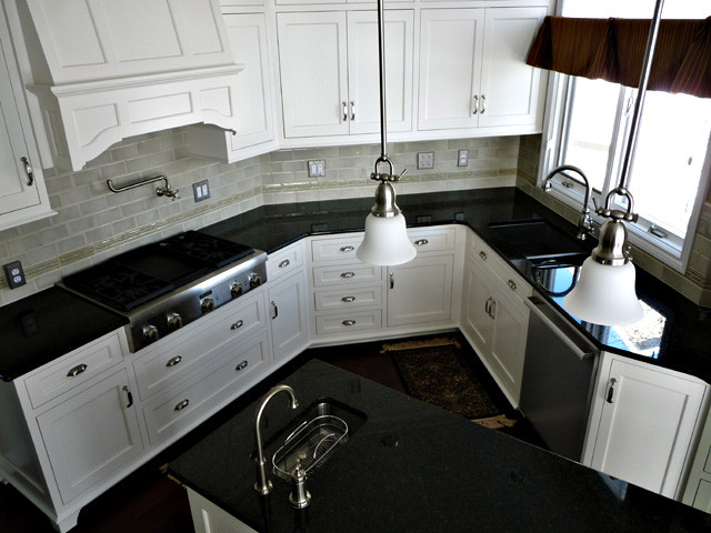 Eat-in kitchen - mid-sized traditional u-shaped dark wood floor eat-in kitchen idea in Other with an undermount sink, beaded inset cabinets, white cabinets, green backsplash, porcelain backsplash, stainless steel appliances and an island