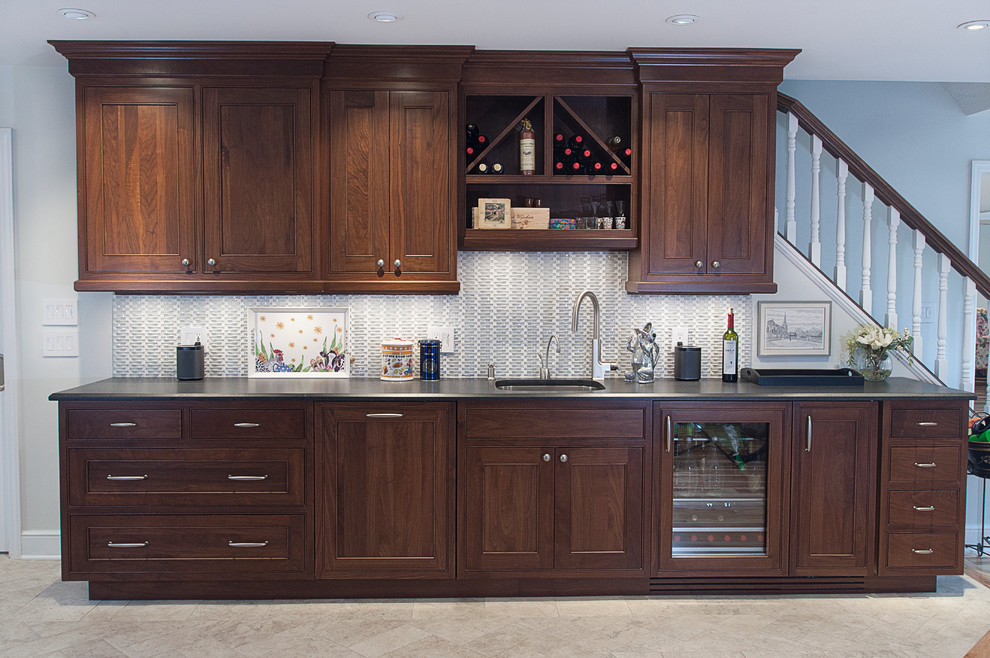 Exempel på ett mellanstort klassiskt kök, med en undermonterad diskho, luckor med profilerade fronter, bruna skåp, granitbänkskiva, grått stänkskydd, rostfria vitvaror och en köksö