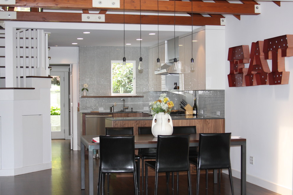 На фото: кухня в современном стиле с фартуком из плитки мозаики, обеденным столом, плоскими фасадами, белыми фасадами, фартуком цвета металлик и техникой из нержавеющей стали с