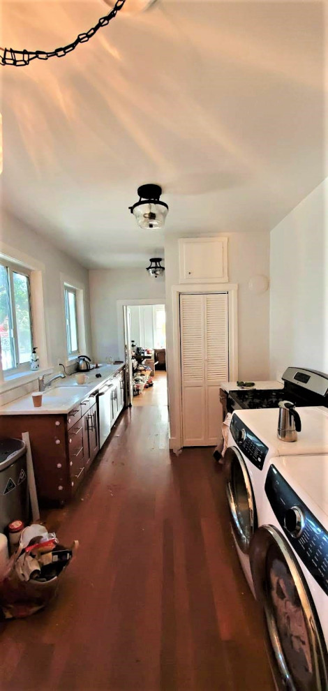 Foto på ett avskilt, litet retro vit kök, med en rustik diskho, skåp i shakerstil, vita skåp, bänkskiva i kvarts, vitt stänkskydd, rostfria vitvaror, vinylgolv och brunt golv