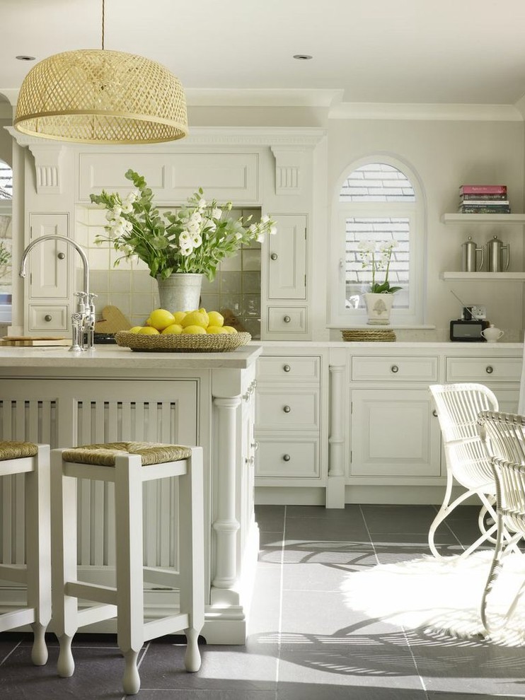 Ejemplo de cocina comedor romántica con armarios con paneles empotrados, puertas de armario blancas, salpicadero verde y una isla