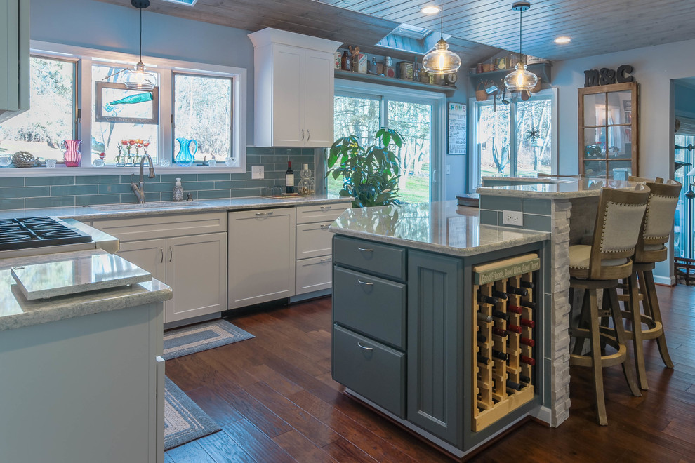Inspiration for a large vintage u-shaped kitchen/diner in Detroit with a submerged sink, shaker cabinets, blue cabinets, engineered stone countertops, blue splashback, glass tiled splashback, stainless steel appliances, medium hardwood flooring, an island, brown floors and grey worktops.