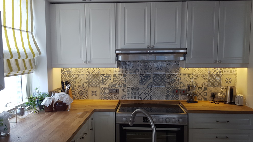 Foto di una cucina ad U shabby-chic style di medie dimensioni con ante a persiana e ante bianche