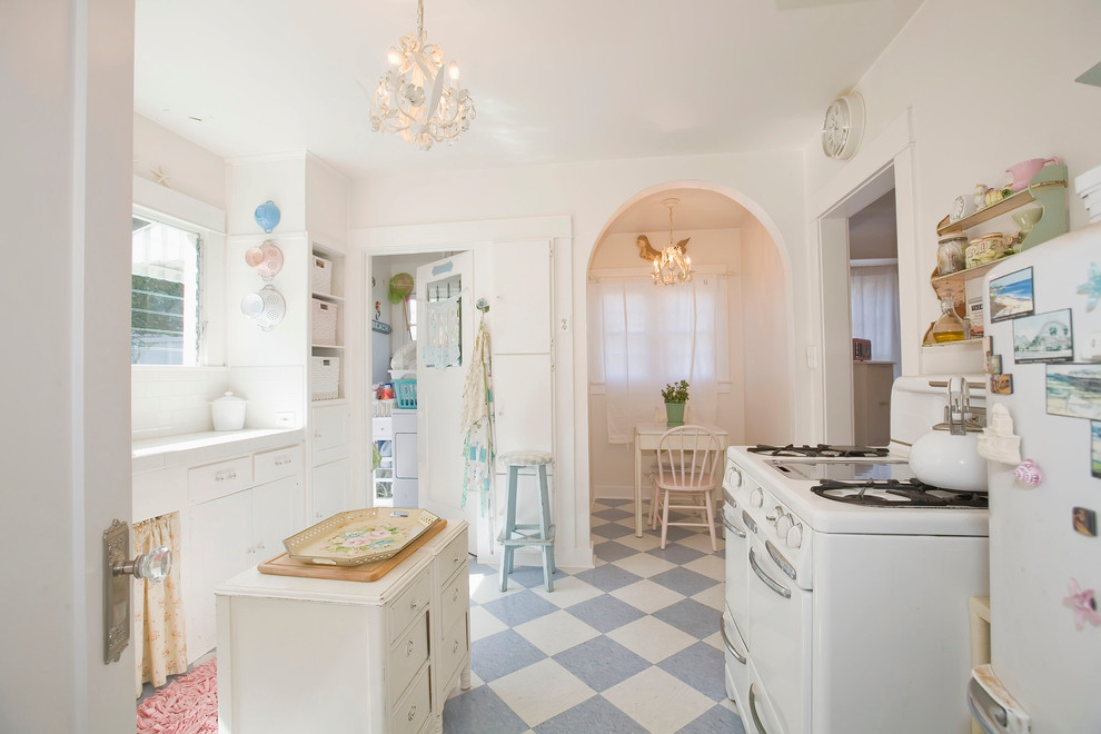 Zweizeilige Shabby-Style Küche mit weißen Schränken, Küchenrückwand in Weiß, weißen Elektrogeräten und Kücheninsel in Phoenix