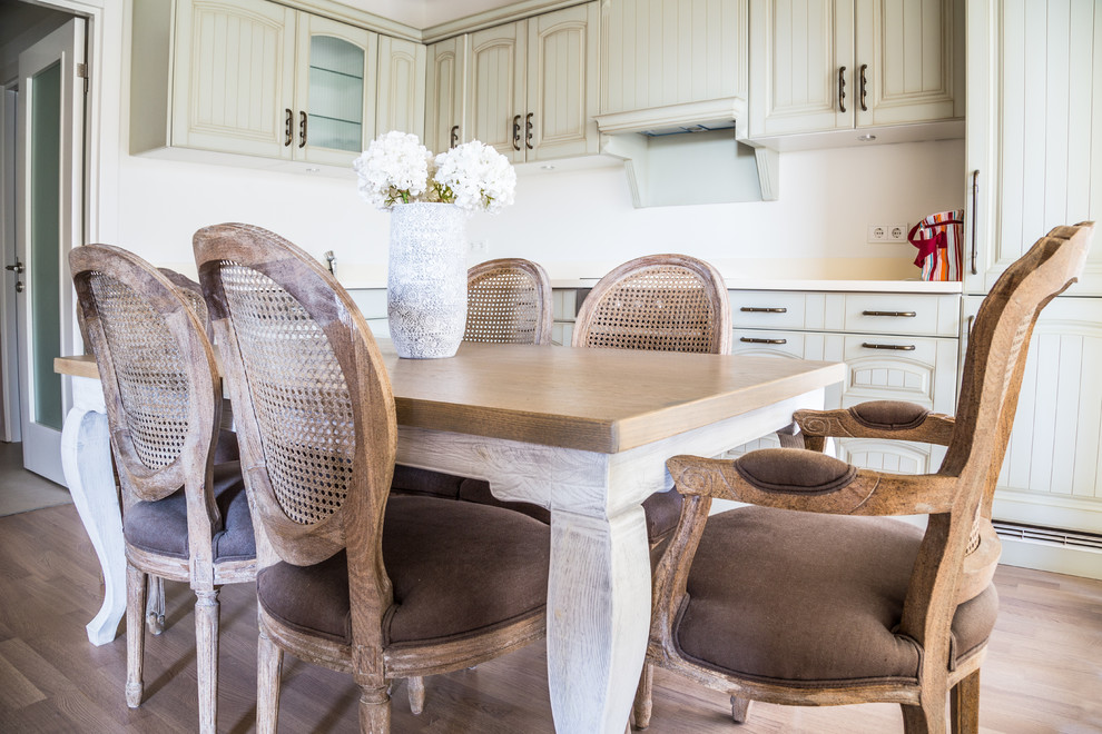 Esempio di una cucina di medie dimensioni con lavello sottopiano, ante a persiana, ante beige, top in superficie solida, elettrodomestici da incasso, pavimento in legno massello medio e pavimento marrone