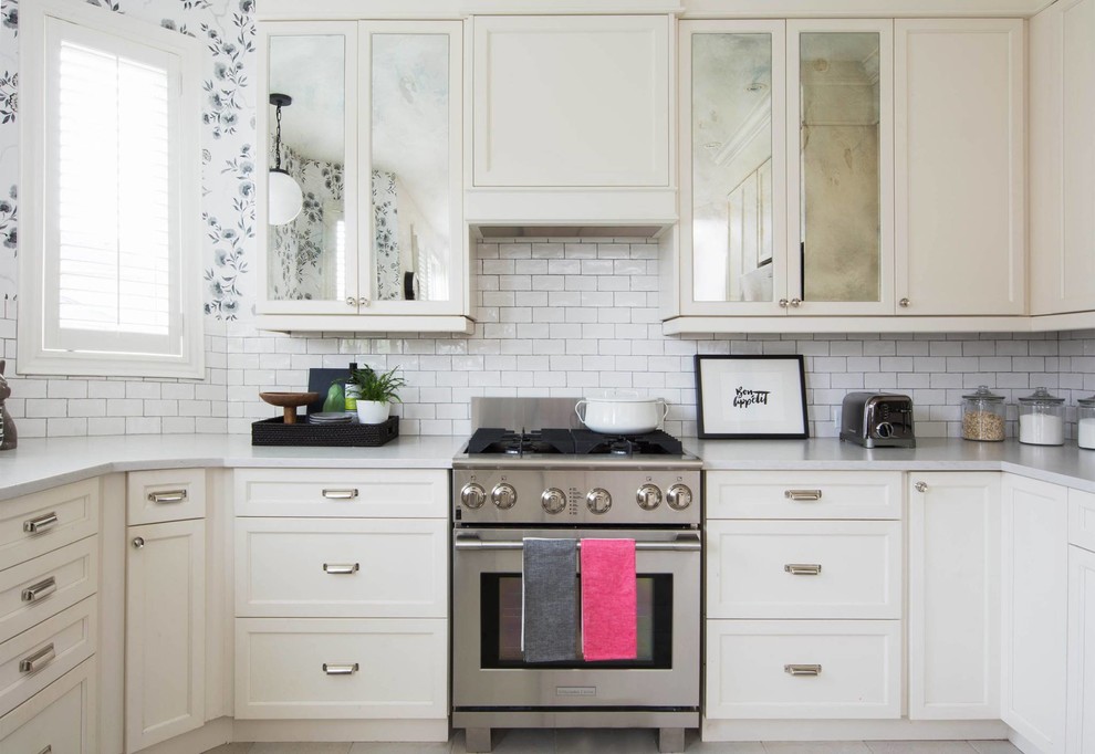 Inredning av ett shabby chic-inspirerat litet kök, med luckor med infälld panel, vita skåp, bänkskiva i kvarts, vitt stänkskydd, stänkskydd i keramik, rostfria vitvaror och travertin golv