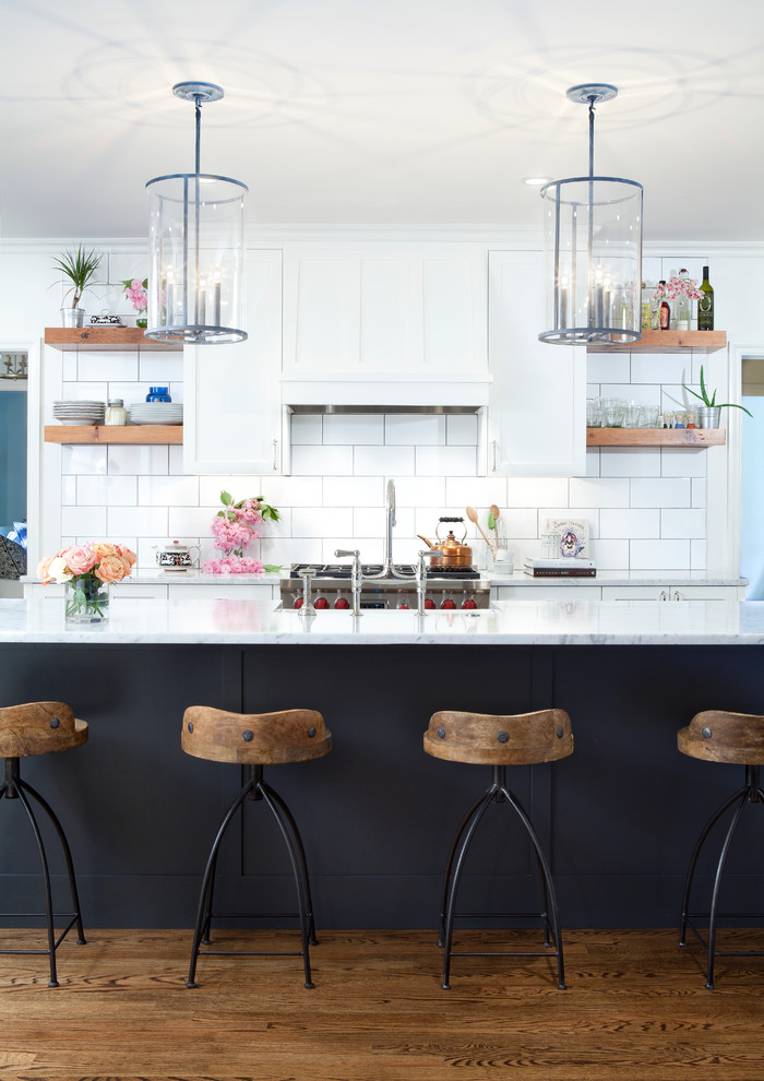 Zweizeilige Shabby-Style Küche mit Schrankfronten im Shaker-Stil, weißen Schränken, Marmor-Arbeitsplatte, Küchenrückwand in Weiß, Rückwand aus Metrofliesen, braunem Holzboden und Kücheninsel in Baltimore