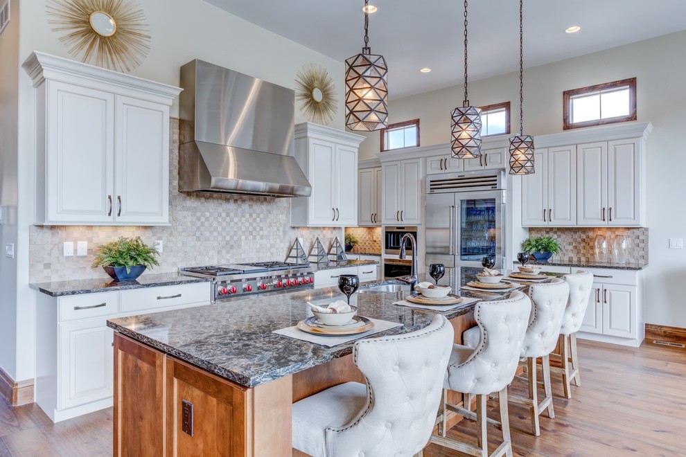 Inspiration for a traditional u-shaped kitchen in Denver with a double-bowl sink, raised-panel cabinets, white cabinets, grey splashback, stainless steel appliances, medium hardwood flooring and an island.