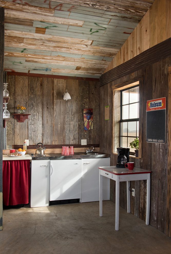 Idéer för små rustika kök, med en integrerad diskho, släta luckor, vita skåp, bänkskiva i rostfritt stål, betonggolv och en köksö