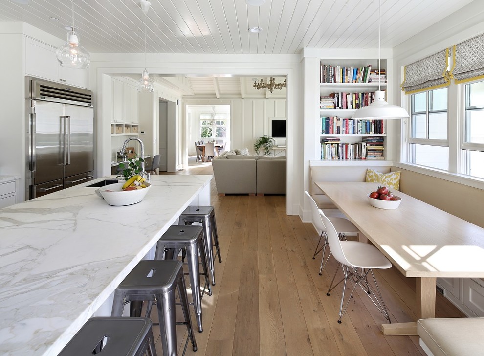 Example of a farmhouse open concept kitchen design in San Francisco with an undermount sink, white cabinets and stainless steel appliances
