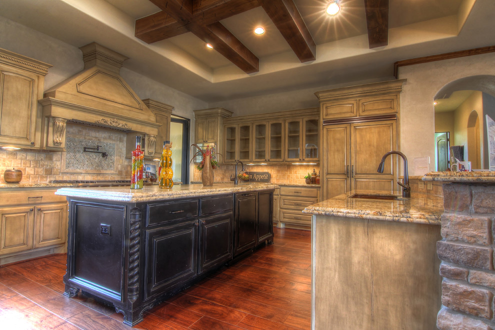 Photo of a large mediterranean u-shaped open plan kitchen in Houston with a submerged sink, raised-panel cabinets, medium wood cabinets, granite worktops, beige splashback, mosaic tiled splashback, integrated appliances, dark hardwood flooring, an island and brown floors.