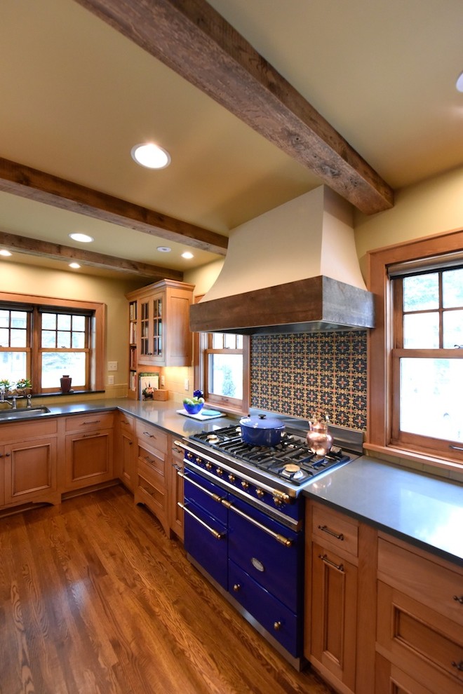 Medelhavsstil inredning av ett kök, med luckor med infälld panel, skåp i mellenmörkt trä, flerfärgad stänkskydd, färgglada vitvaror och mellanmörkt trägolv