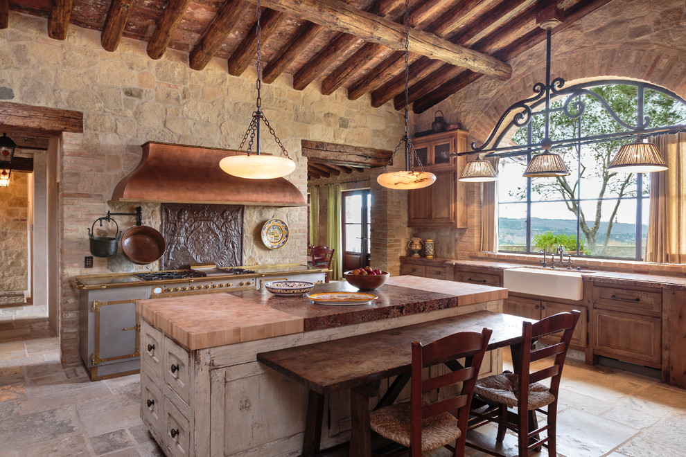 Foto på ett avskilt, stort medelhavsstil brun kök, med en köksö, en rustik diskho, luckor med infälld panel, skåp i mellenmörkt trä, träbänkskiva, brunt stänkskydd, stänkskydd i stenkakel, färgglada vitvaror och grått golv