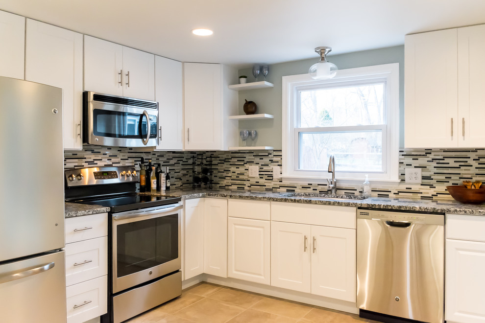 Transitional l-shaped ceramic tile enclosed kitchen photo in Cincinnati with an undermount sink, shaker cabinets, white cabinets, granite countertops, multicolored backsplash, glass tile backsplash, stainless steel appliances and no island