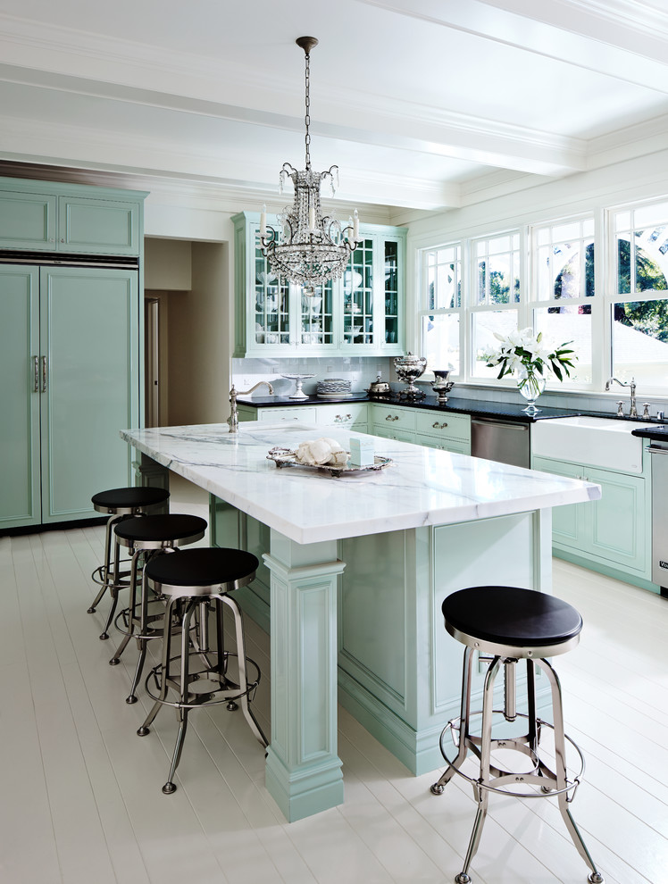 Inredning av ett klassiskt mellanstort kök, med en rustik diskho, luckor med infälld panel, gröna skåp, marmorbänkskiva, vitt stänkskydd, integrerade vitvaror, målat trägolv och en köksö