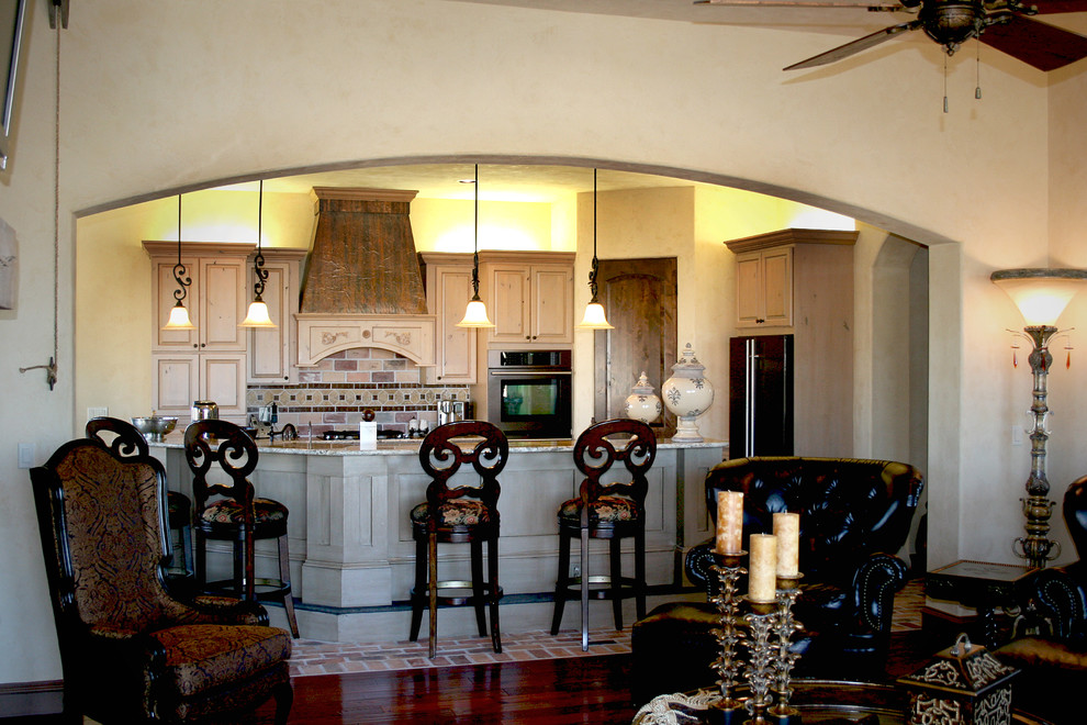 Rustikale Wohnküche mit profilierten Schrankfronten, hellen Holzschränken, Granit-Arbeitsplatte, Küchenrückwand in Beige, Rückwand aus Steinfliesen, Backsteinboden und Kücheninsel in Austin