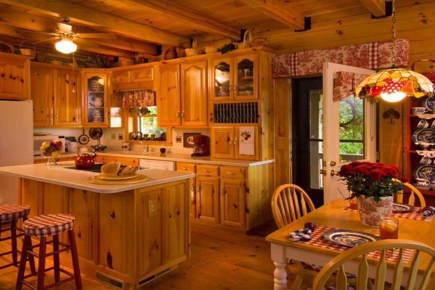 Inspiration for a mid-sized rustic l-shaped medium tone wood floor eat-in kitchen remodel in Nashville with an undermount sink, raised-panel cabinets, medium tone wood cabinets, solid surface countertops, beige backsplash, white appliances and an island
