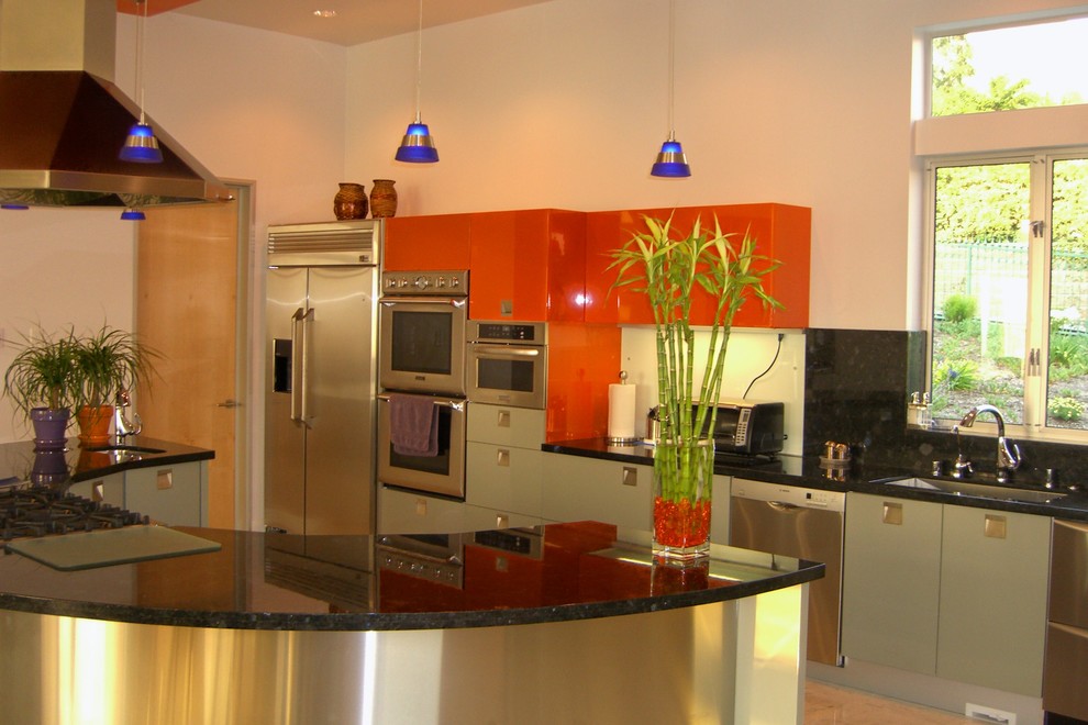 Modern inredning av ett mellanstort linjärt kök med öppen planlösning, med en undermonterad diskho, släta luckor, orange skåp, granitbänkskiva, svart stänkskydd, stänkskydd i sten, rostfria vitvaror, bambugolv och en köksö