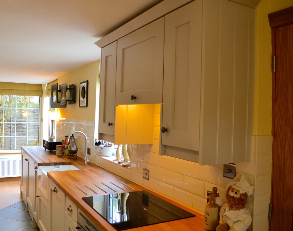 This is an example of a farmhouse kitchen/diner in Oxfordshire with wood worktops.