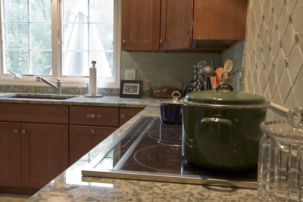 Immagine di una cucina stile americano di medie dimensioni con lavello sottopiano, ante in stile shaker, ante in legno scuro, top in granito, paraspruzzi verde, paraspruzzi con piastrelle in ceramica, elettrodomestici in acciaio inossidabile e pavimento in gres porcellanato