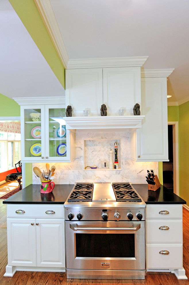 クリーブランドにあるトラディショナルスタイルのおしゃれなキッチン (レイズドパネル扉のキャビネット、白いキャビネット、シルバーの調理設備) の写真