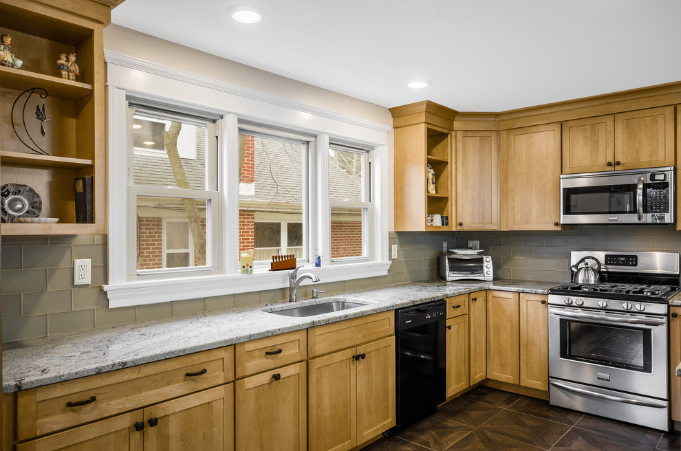 Mid-sized arts and crafts u-shaped linoleum floor eat-in kitchen photo in Philadelphia with an undermount sink, shaker cabinets, light wood cabinets, granite countertops, glass tile backsplash, gray backsplash, black appliances and a peninsula