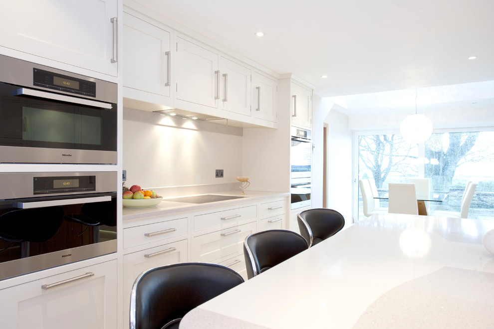 This is an example of a large contemporary open plan kitchen in Other with a submerged sink, shaker cabinets, light wood cabinets, quartz worktops, stainless steel appliances and an island.