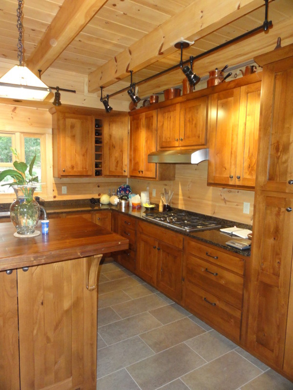 Rustikale Küche mit Schrankfronten im Shaker-Stil, hellen Holzschränken, Arbeitsplatte aus Holz, Keramikboden und Kücheninsel in Sonstige