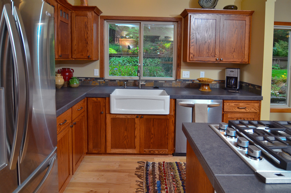 Exempel på ett amerikanskt kök, med en rustik diskho, skåp i shakerstil, skåp i mellenmörkt trä, kaklad bänkskiva, flerfärgad stänkskydd, rostfria vitvaror, ljust trägolv och en köksö